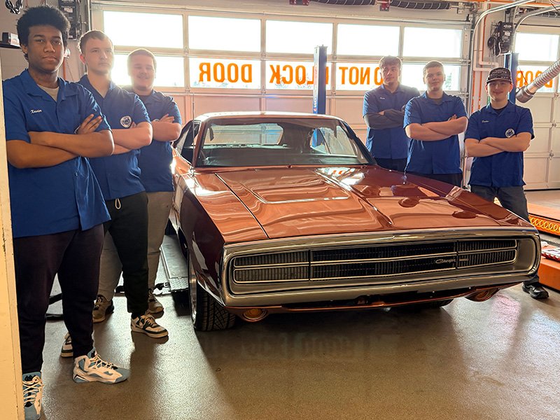 Class of 2026 students standing beside the 1970 Dodge Charger